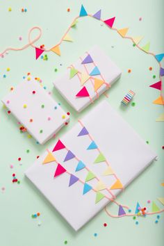 three pieces of cake sitting on top of a table covered in confetti and streamers