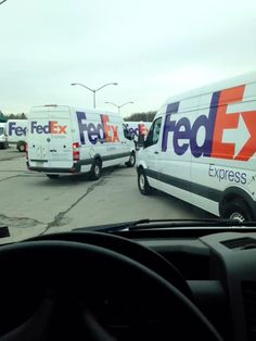 two fed ex vans parked in a parking lot