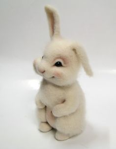 a small white stuffed animal sitting on top of a table