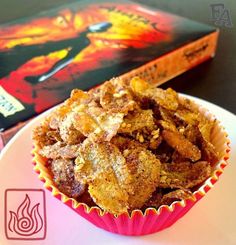 a plate with some food on top of it next to a book and a cupcake