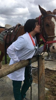 a woman kissing a horse on the nose