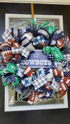 a wreath with the word cowboys on it and american flags attached to it, hanging in front of a door