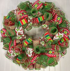 a christmas wreath with green and red ribbons