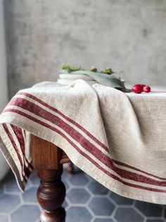 a wooden table topped with a white and red blanket