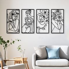 three black and white paintings on the wall above a couch