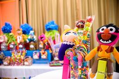 an assortment of candy and candies on display in front of a table with stuffed animals