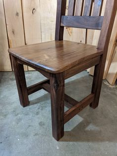 a wooden chair sitting on top of a cement floor