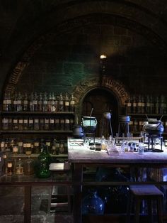 a room filled with lots of bottles next to a table and stools in front of it