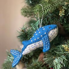 a blue ornament hanging from a christmas tree