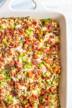 a casserole dish with bacon, green peppers and cheese in it on a white surface