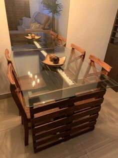 a glass table with wooden chairs around it