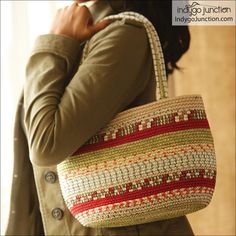 a woman is holding a woven bag in her hands