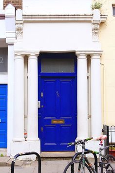 two bikes parked in front of a blue door