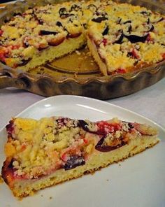 a pie sitting on top of a white plate next to a pan filled with cake