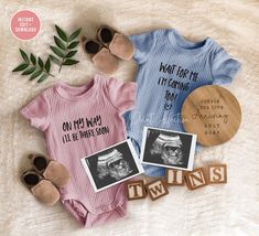 two baby onesuits with their pictures on them and the words twins written in wood blocks