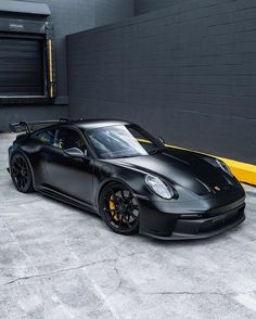 a black sports car parked in front of a building