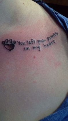 a woman with a tattoo on her chest saying you left paw prints on my heart