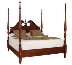 a wooden bed with four posts and pillows on it's headboard, against a white background