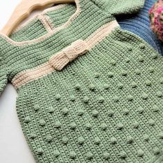 two knitted sweaters and a wooden hanger