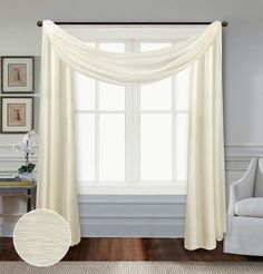 a living room with a white curtain and chair in front of the window, along with pictures on the wall