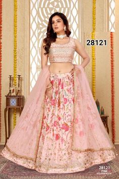 In a whisper of romance, the blush pink lehenga choli set blooms with bold floral patterns that burst across the fabric. Each flower, embroidered with meticulous detail, speaks of elegance and vitality, creating a vibrant tapestry. The embroidered border adds a touch of intricate charm, framing the bold blooms with delicate artistry. Adorned in this ensemble, she embodies a perfect blend of soft allure and striking beauty, radiating grace with every step. * Pre stitched lehenga for women. * Crafted from a Georgette fabric for luxurious feel and touch. * The blouse features sequin embroidery throughout. * The sleeveless blouse features back opening with hook closure and tie ups * Dry clean or hand wash for longer life. Note: Colors may slightly vary due to photographic l Pink Floral Embroidered Semi-stitched Lehenga, Pink Floral Print Festive Sets, Festive Pink Floral Print Sets, Pink Floral Print Unstitched Lehenga, Pink Floral Print Lehenga Unstitched, Traditional Pink Floral Print Sets, Fitted Pink Floral Embroidered Set, Fitted Pink Sets With Floral Embroidery, Pink Semi-stitched Lehenga With Floral Embroidery