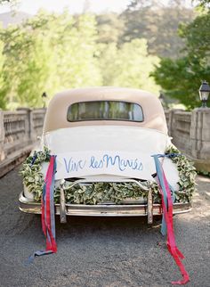 an old car is decorated with flowers and ribbon for the bride's wedding day