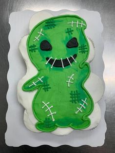 a decorated cookie with green frosting and white icing