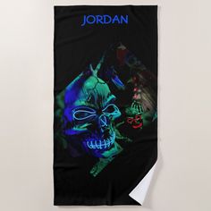 a black towel with a blue and green image of two demonic looking faces on it