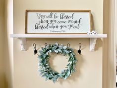 a wreath is hanging on the wall next to a sign that says, you will be loved