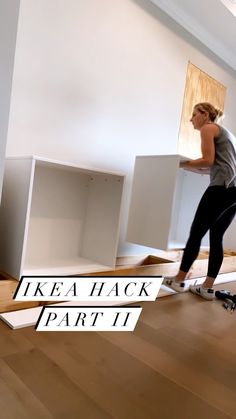 a woman riding a skateboard on top of a wooden floor next to white boxes