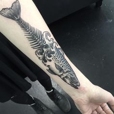 a man's arm with a fish tattoo on it