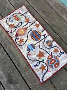 an old rug is sitting on a wooden deck with wood planks in the background