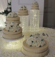 three tiered wedding cake with white flowers on the top and side, sitting on a table