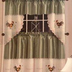 the window is decorated with roosters and ruffled curtains