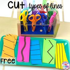 a tray with scissors and cut types of lines on it next to a cup full of paper clips