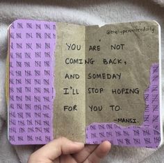 someone is holding up an open book with writing on it and the words you are not coming back, and somebody i'll stop hoping for you to