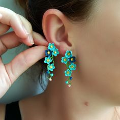 a close up of a person wearing some kind of earrings with flowers on it's ear