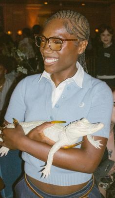 a woman holding an alligator in her arms