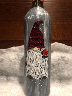 a glass bottle with an image of a gnome on the front and bottom, sitting on snow