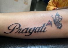 a person with a butterfly tattoo on their arm that says pragat and butterflies