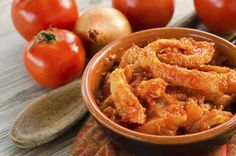 a bowl filled with fried food next to tomatoes