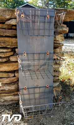 a large metal box with several compartments on it sitting next to some rocks and trees