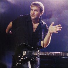 a man in black shirt playing guitar on stage