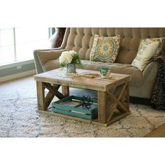 a living room with a couch, coffee table and rug on the floor in front of it