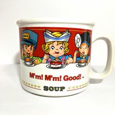 a coffee mug with the words mmm mm good soup on it and three children eating