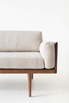 a white couch sitting on top of a wooden frame