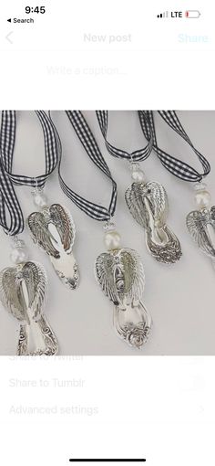 several silver necklaces are displayed on a white table with black and white checkered ribbon