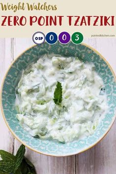 a bowl filled with white sauce and mint leaves