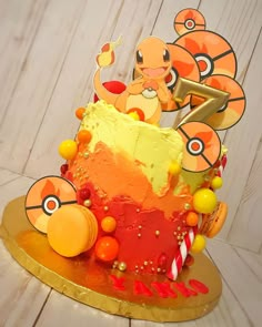 a pokemon themed birthday cake on a gold platter with candy and candies around it