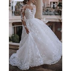 a woman in a white wedding dress posing for the camera with her hand on her hip